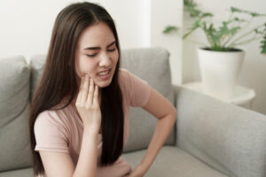 The young woman has tooth pain and suffering in Atlanta, GA 