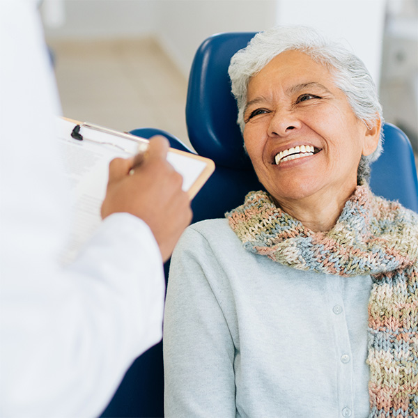 Dentist having friendly conversation with his patient regarding her dental health,GA