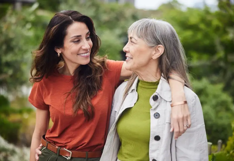 Woman walking in a park smiling with her mother