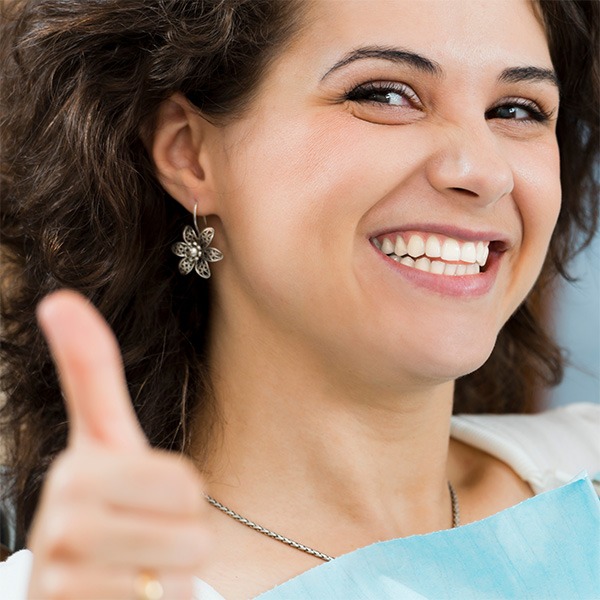 Thumbs-up gesture by a woman after a successful non-surgical facial treatment in Atlanta, GA